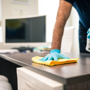 Man disinfecting an office desk